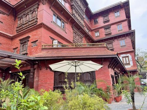 a building with an umbrella in front of it at Hotel Dachi Kathmandu - Bhaktapur in Bhaktapur
