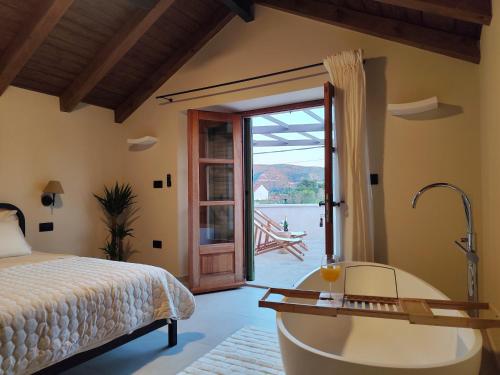 a bedroom with a tub and a bed and a door at Villa Maranta in Slano