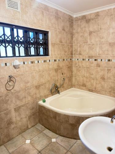 a large bathroom with a tub and a sink at The Cozy Corner House in Durban