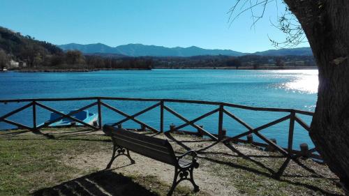 a bench sitting next to a fence next to a lake at La Casa Sul Lago in Posta Fibreno