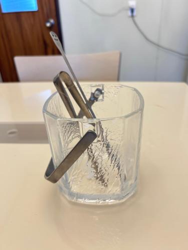 a pair of scissors in a glass bowl on a table at Classy仏生山 in Takamatsu
