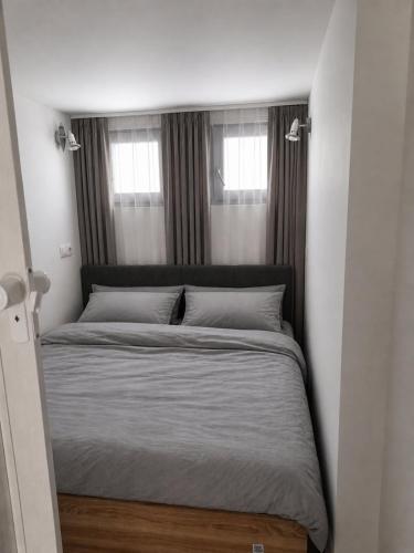 a bed in a small room with two windows at Goga2 in Pirovac