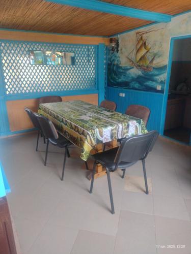 a dining room with a table and chairs and a painting at Casa de vacanta ,,Puiu & Nelly,, in Sulina