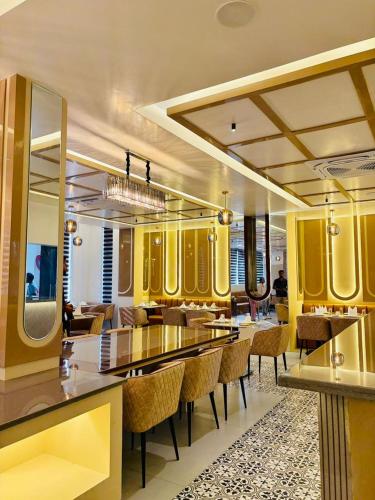 a restaurant with yellow walls and tables and chairs at Regal Havens in Jorhat
