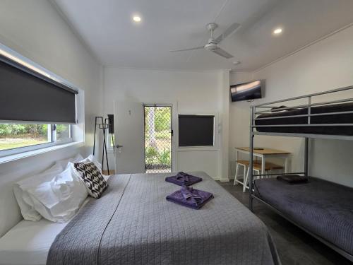a bedroom with a bed and a bunk bed at Peninsula Caravan Park Cooktown in Cooktown