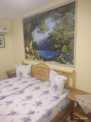 a bedroom with a bed with a painting on the wall at Casa de vacanta ,,Puiu & Nelly,, in Sulina