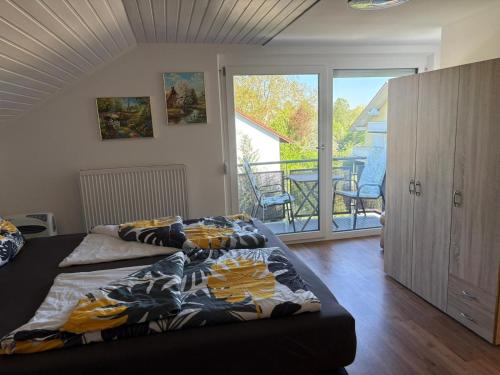 two beds in a bedroom with a balcony at Appartementhaus Silke in Bad Füssing