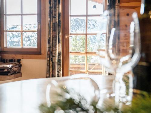a wine glass sitting on a table in front of a window at Rustic Hut Salzburg near Ski Slopes in Bramberg am Wildkogel