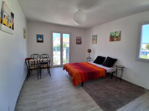 a bedroom with a bed and a table and chairs at Maison avec piscine in Cessenon