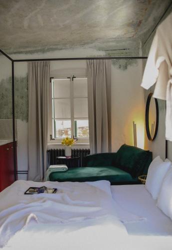 a bedroom with a bed and a green couch at Domeček / Tiny House in Český Krumlov
