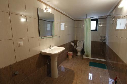 a bathroom with a sink and a toilet at Θέα - View Appartments in Paralía Kímis