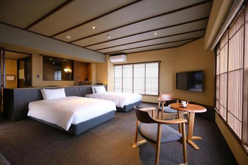 a hotel room with two beds and a table and a chair at Suwakoen in Suwa