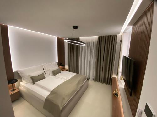 a bedroom with a white bed and a television at Pearl Garden in Primošten