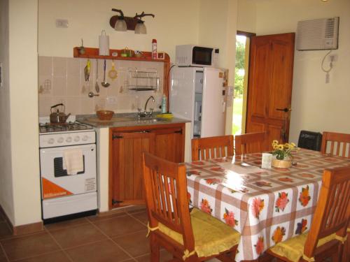 a kitchen with a table and a stove and refrigerator at Complejo La Colina in Federación