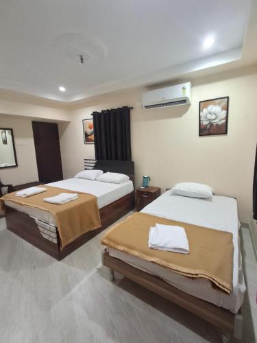 a hotel room with two beds and a heater at Rgn Residency in Singānallūr