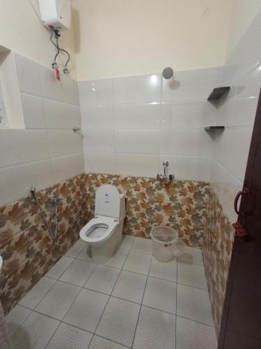 a bathroom with a toilet and a sink at Rgn Residency in Singānallūr