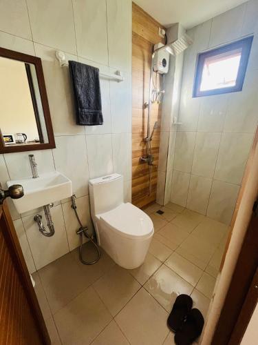 a bathroom with a toilet and a sink and a shower at Beachfront Studio with Cozy and Spacious Balcony in Baling