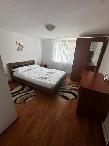 a bedroom with a bed and a wooden floor at Casa Izvorul Rece in Hobiţa
