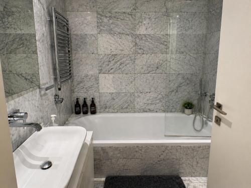 a bathroom with a white tub and a sink at FINELINE Villa in Limassol