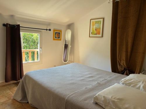 a bedroom with a bed and a phone on the wall at Maison Les Pieds dans l eau in Farinole