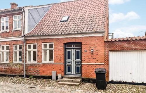 a red brick house with a blue door at 4 Bedroom Awesome Home In Ribe in Ribe