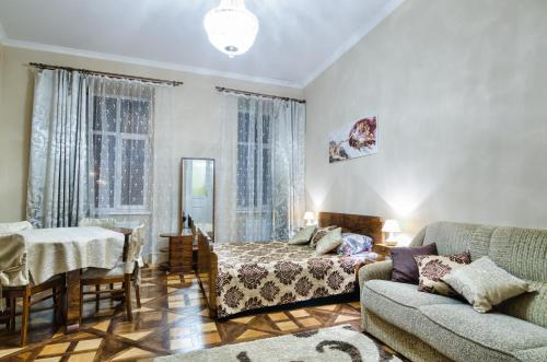 uma sala de estar com um sofá e uma cama em Modern and Classic apart. Central location em Lviv