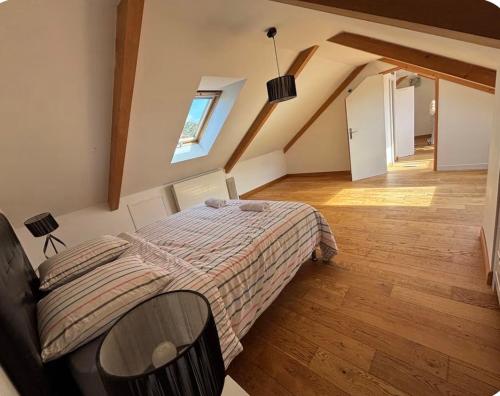 a bedroom with a bed and a wooden floor at Villa Sauna & mer in Sainte-Adresse