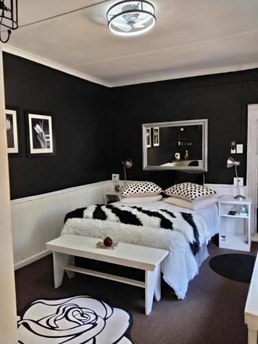 a black and white bedroom with a bed and a table at Prosper Stud Guest House in Robertson