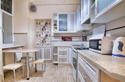 uma cozinha com armários brancos e uma bancada em Modern and Classic apart. Central location em Lviv