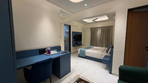 a room with a bedroom with a bed and a desk at Palm Suites Baner- indian nationals only in Pune