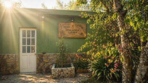 a green house with a sign on the side of it at PINE-APPALE Riverside Resort in Ấp Kế Mỹ
