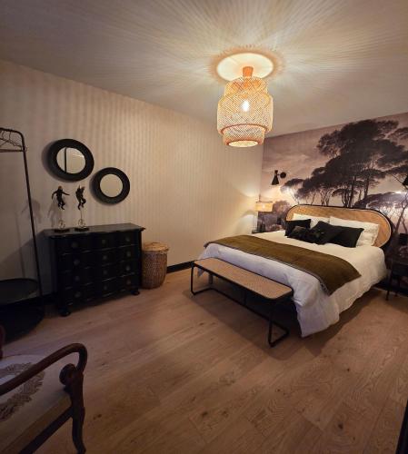 a bedroom with a large bed and a chandelier at Les Preuses, un Grand Cru de Chablis avec jacuzzi in Fontenay-près-Chablis