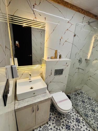 a white bathroom with a sink and a toilet at HR The nature resort in Birbhaddar