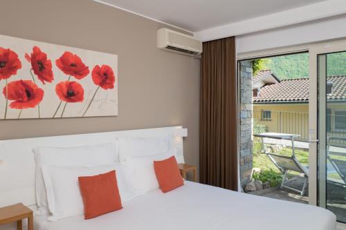 a bedroom with a bed with red flowers on the wall at Parco San Marco Lifestyle Beach Resort in Porlezza
