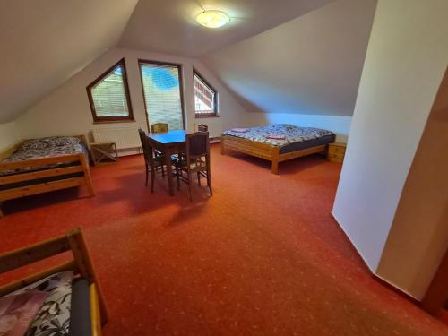 a room with a table and a bed and chairs at Vila Rozmital in Příbram