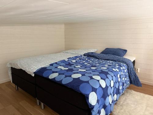 a bedroom with a blue and white comforter on a bed at Lilla Risingegården in Risinge