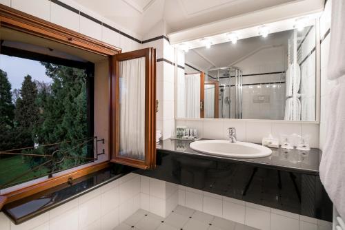 a bathroom with a sink and a large mirror at Villa Margherita in Mira