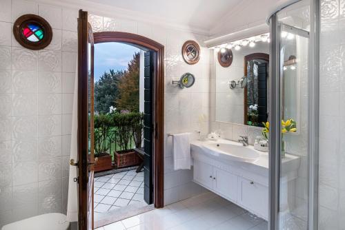 bagno con lavandino e specchio di Romantik Hotel Villa Margherita a Mira