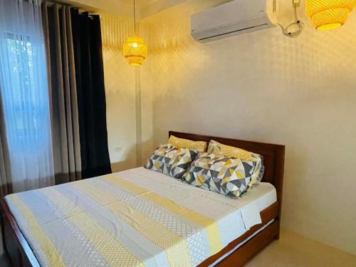 a bedroom with a bed with a yellow and white comforter at Beachfront Studio with Cozy and Spacious Balcony in Baling