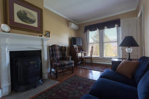 a living room with a blue couch and a fireplace at The Inn at Manchester in Manchester
