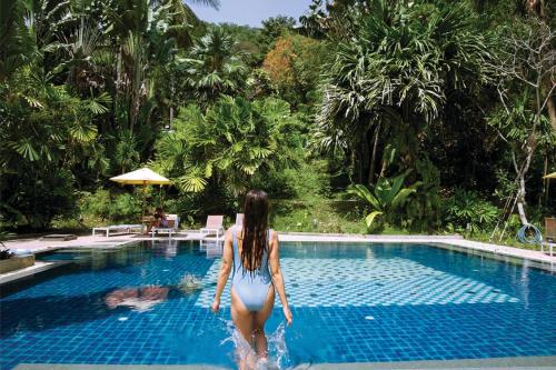 a woman in a bikini walking into a swimming pool at Marina Express-Fisherman Aonang in Ao Nang Beach