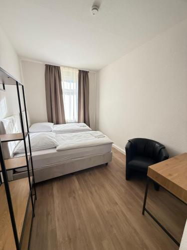 a bedroom with a bed and a chair and a window at Gästehaus E&E in Nierstein
