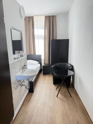 a bathroom with a bed and a sink and a chair at Gästehaus E&E in Nierstein