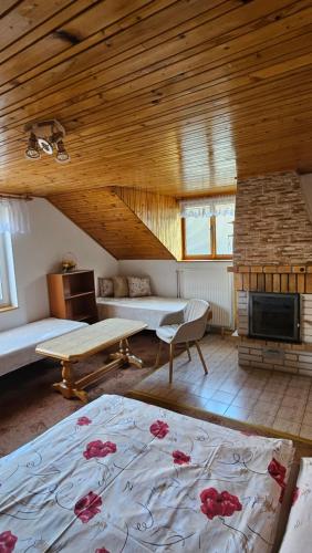 a living room with a bed and a fireplace at Privát Marika in Terchová