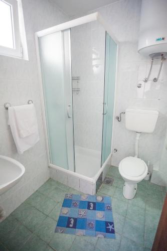 a bathroom with a toilet and a glass shower at Panorama Apartments in Budva