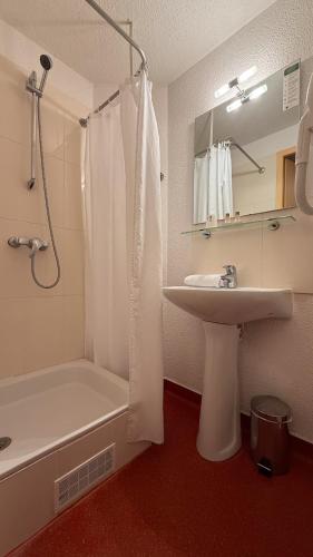 a bathroom with a sink and a tub and a shower at Hotel de L'Opéra in Bordeaux