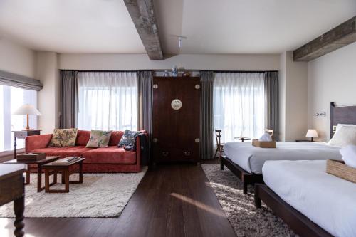 a hotel room with two beds and a red couch at 云溪 表參道 in Tokyo