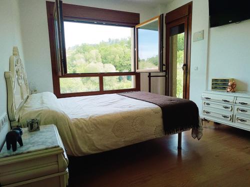 a bedroom with a bed and a large window at Casa Agarimo in Arcade