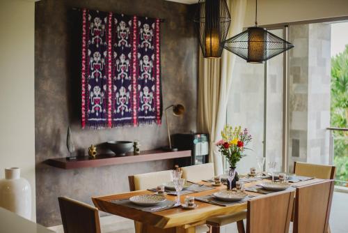 a dining room with a table with chairs and a flag at Luxury Apartment at AYANA Residences in Jimbaran