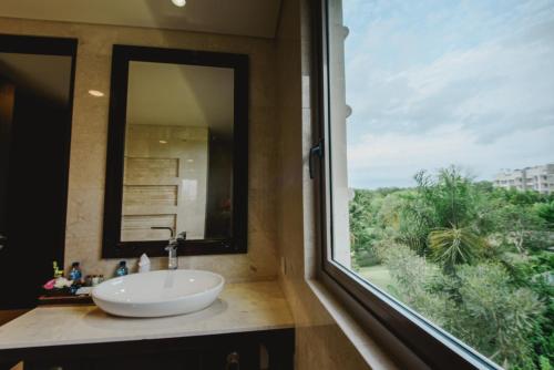 a bathroom with a sink and a large window at Luxury Apartment at AYANA Residences in Jimbaran